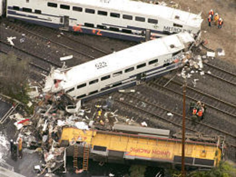 Investigators examine the wreckage of a train derailment Wednesday in Glendale, Calif. A commuter train struck a Jeep, derailed and hit another commuter train early Wednesday, killing at least 11 people and injuring more than 180 others.