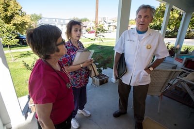 Shirley Belleville, left, Cindi Xiras-Keane and Dr. Scott Poppen knock on a door to rally support for Proposition 3, a ballot initiative that would raise the sales tax for Medicaid expansion, in Salt Lake City on Saturday, Oct. 13, 2018.