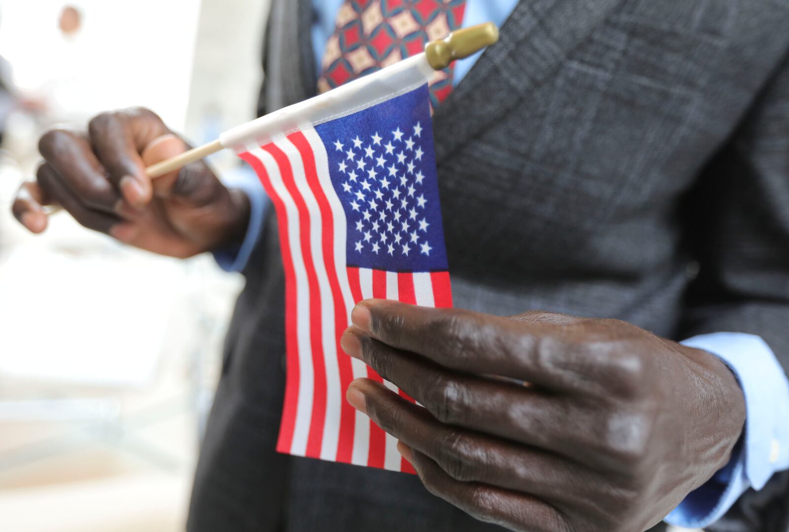 A refugee man holds an American Flag at the Capitol in Salt Lake City.