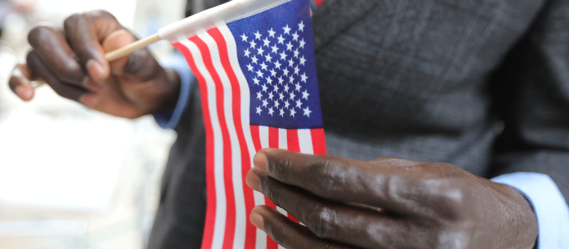 A refugee man holds an American Flag at the Capitol in Salt Lake City.
