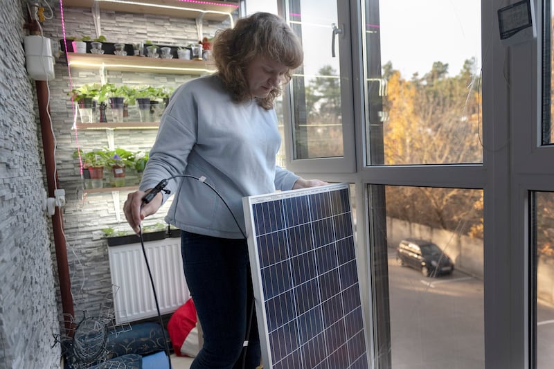 Kyiv resident Anna shows a solar panel that can provide energy for an entire apartment for four hours in Kyiv, Ukraine.