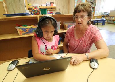 Oquirrh Elementary School student Aameeyah Lansing reads with the help of teacher assistant Dorothy Burrup in Kearns on Wednesday, July 18, 2018.