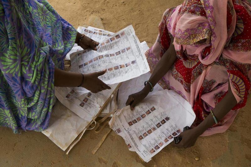 Voters look for their names on voter lists scattered on the ground at the main polling place in Kidal, Mali Sunday, July 28, 2013. Chaos reigned at Kidal's main polling station, where voters struggled to find their names on voter rolls, and lists posted o