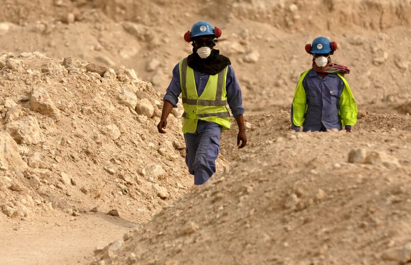 Workers walk back to a worksite being built for the 2022 World Cup, in Doha, Qatar.