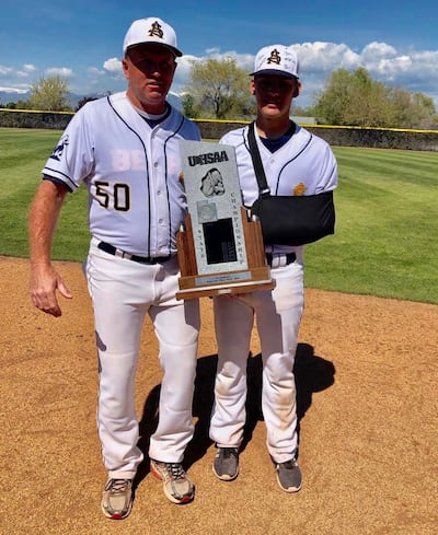 Summit Academy assistant Gary Hamblin poses with the 3A state second-place trophy with his son, Kolby.