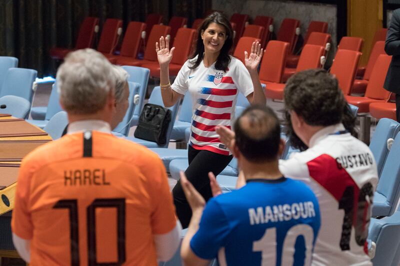 American Ambassador to the United Nations Nikki Haley, center, is applauded by other members of the Security Council as she arrives for a photo opportunity of the Ambassadors wearing the jerseys of their country's soccer teams, Thursday, June 14, 2018, at