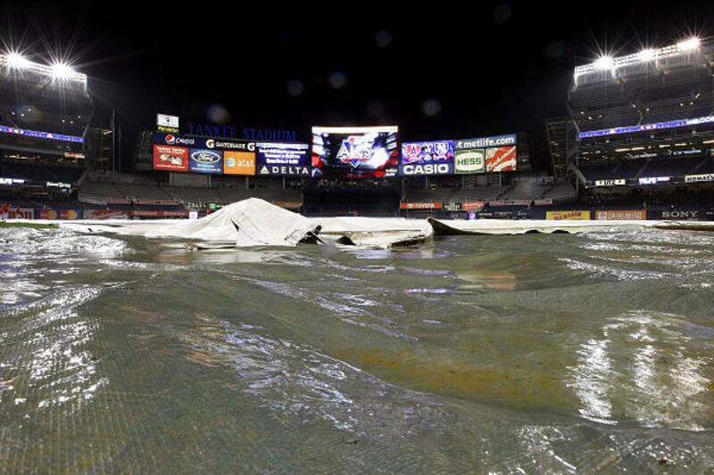 Rainwater drifts over the tarp covering the infield at Yankee Stadium before Game 6.