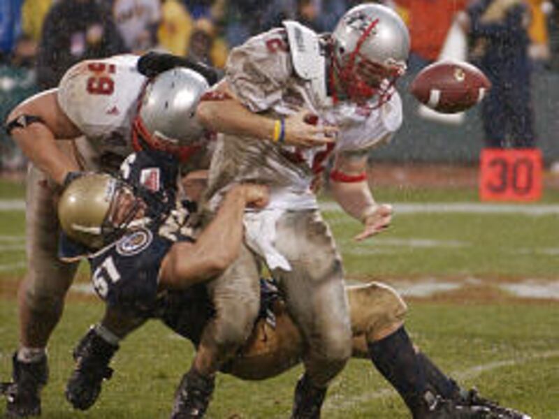 Lobo quarterback Kole McKamey fumbles as he is tackled by Navy's Bobby McClarin in the Emerald Bowl.