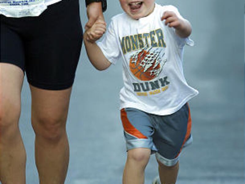 Lindi Salmond and her son Caleb of Bountiful cross the finish line in Thursday's Deseret News 5K Future Walk.