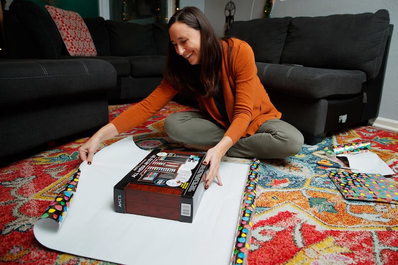 Heather Aliano wraps Christmas presents for her children on Wednesday, Nov. 28, 2018, in Bellevue, Nebraska. Aliano, a mother of four, limits the number of gifts her children receive at Christmas.