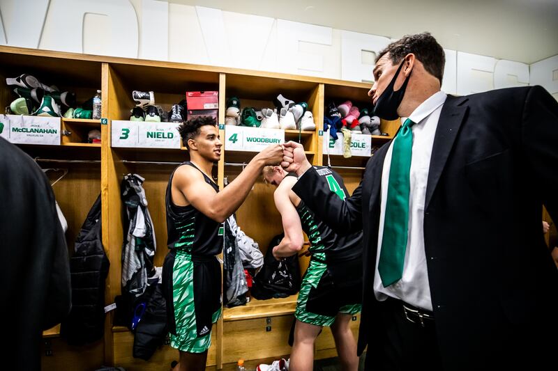 Left, Blaze Nield fist bumps UVU head coach Mark Madsen after a game against Adam State in 2020.