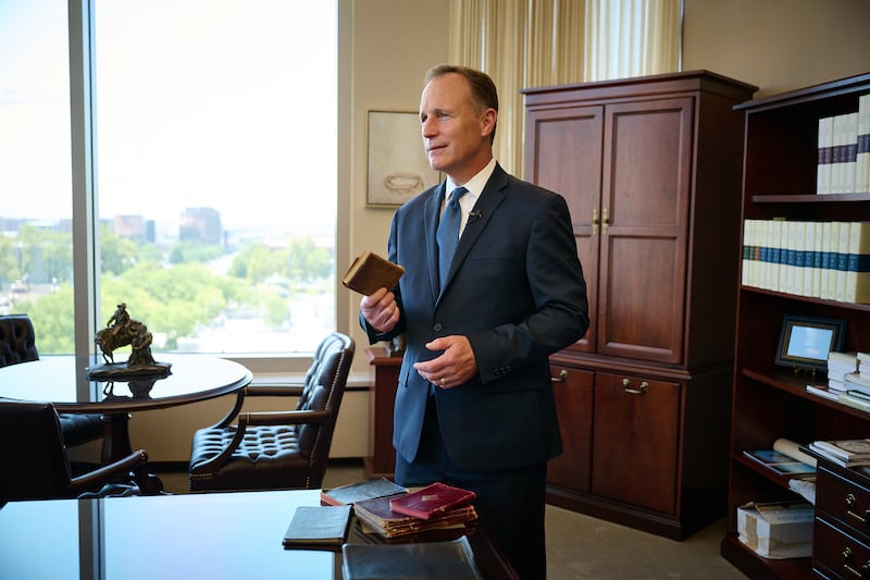 Elder Kyle S. McKay, church historian and recorder, holds the missionary journal of his great-grandfather.