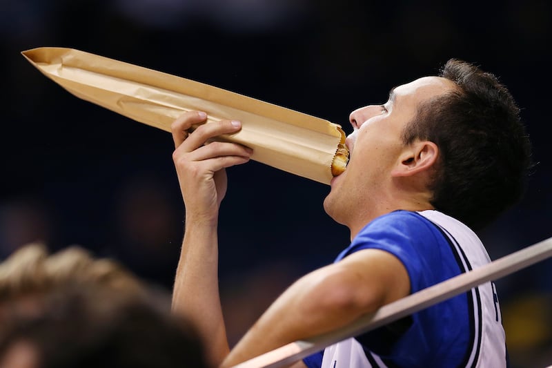 A BYU fan eats a Cougar Tail prior to tipoff as BYU and Colorado College play in Provo on Wednesday, Nov. 8, 2017.