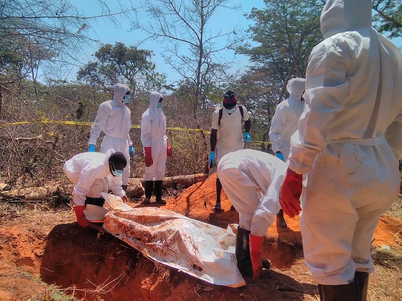 Forensic investigators remove the bodies of 26 suspected Ethiopian migrants from a mass grave on Friday, Oct. 21, 2022.