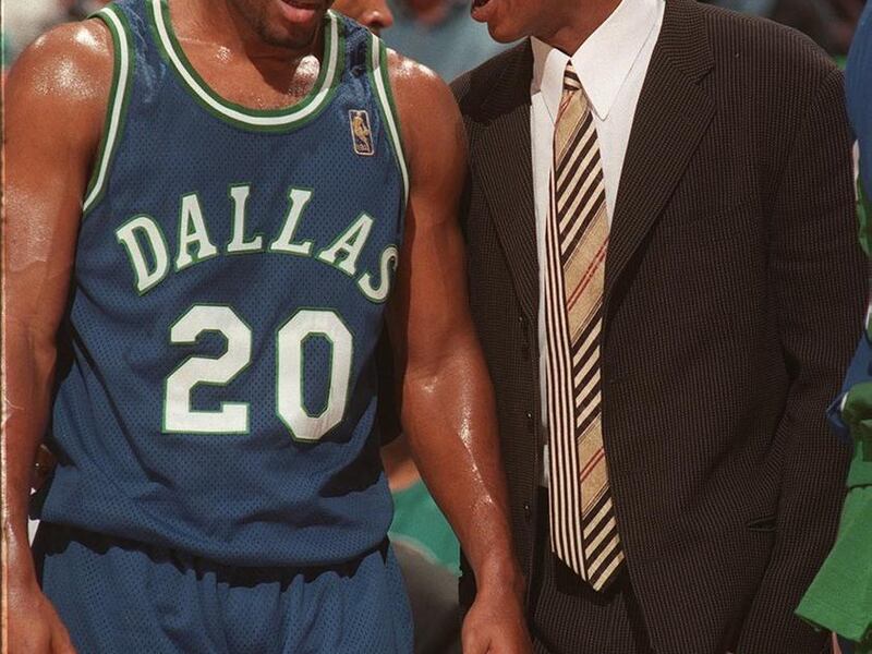 Derek Harper (at right, injured) jumps off the bench to give Erick Strickland a few pointers during game against Jazz March 5, 1997. The fans booed Harper after his comments about not wanting to be traded to the Jazz.