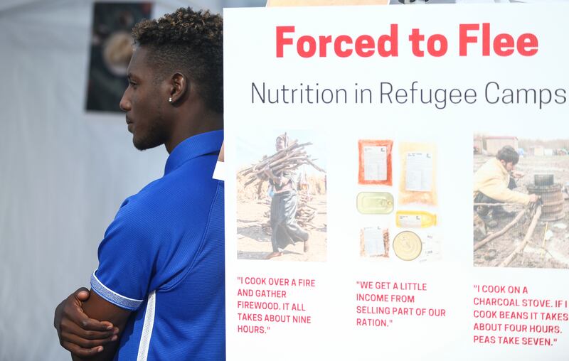 Former refugee from Uganda, Ntezey Swalita, 19, listens to presentations during Catholic Community Services of Utah second annual refugee camp exhibit at Gallivan Plaza in Salt Lake City on Monday, June 10, 2019. Participants heard the personal stories fr
