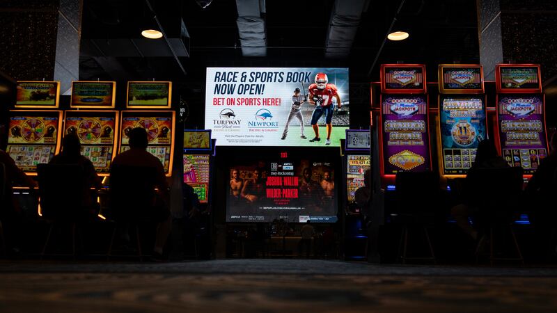 A huge TV screen near a restaurant’s entrance, flanked by electronic gaming machines, promotes sports betting at Turfway Park Racing & Gaming, Dec. 22, 2023, in Florence, Ky.