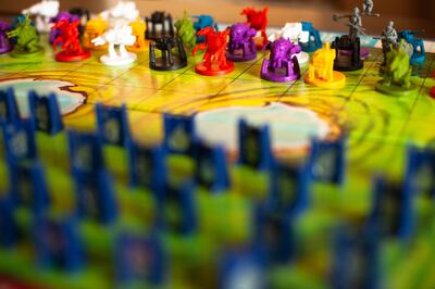 Pieces from "Stratego," a two-player classic board game, and "Scythe," a modern designer game.