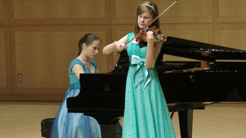 Fourteen-year-old pianist Anastasia Magomedova and 13-year-old violinist Aubree Oliverson in a performance.