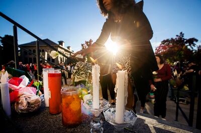 Those attending the vigil for University of Utah student-athlete Lauren McCluskey place flowers, cards and candles on the steps of the Park Building at the University of Utah in Salt Lake City on Wednesday, Oct. 24, 2018. McCluskey was killed Monday, Oct.
