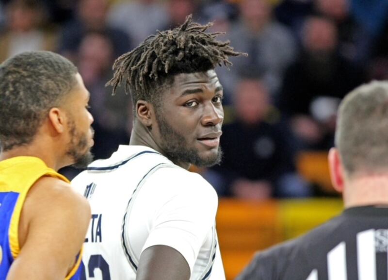 Utah State center Neemias Queta looks back at an official
