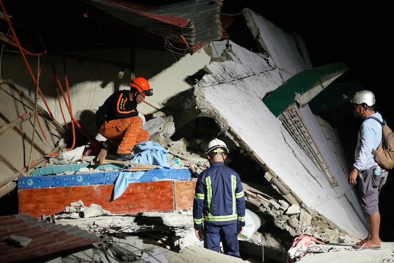 Rescuers check for survivors in the ruins of a collapsed building on Wednesday, Oct. 1, 2025, after a strong earthquake struck Bogo city, Cebu Province, Central Philippines.