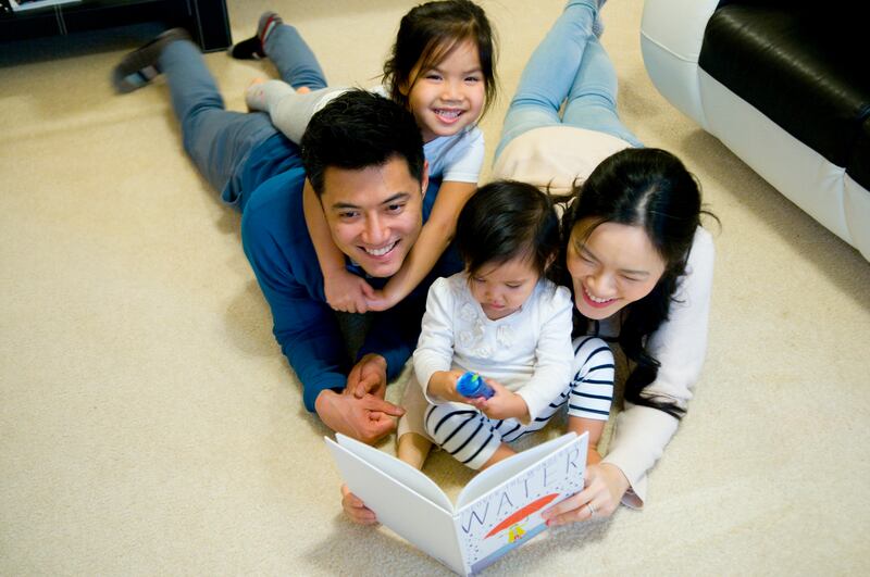 Nelson and Cecilia Yiu read to their two children.