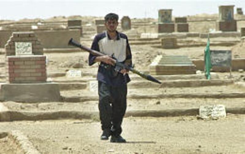 An Iraqi Shiite militiaman leaves a cemetery in Najaf on Wednesday after gunmen loyal to a radical cleric ambushed a patrol of U.S. troops. One U.S. soldier was killed.