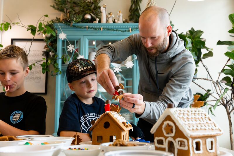 Darin Priday, right, helps his son Zeke, 8, rebuild his fallen gingerbread house at their home in Saratoga Springs on Dec. 3, 2023.