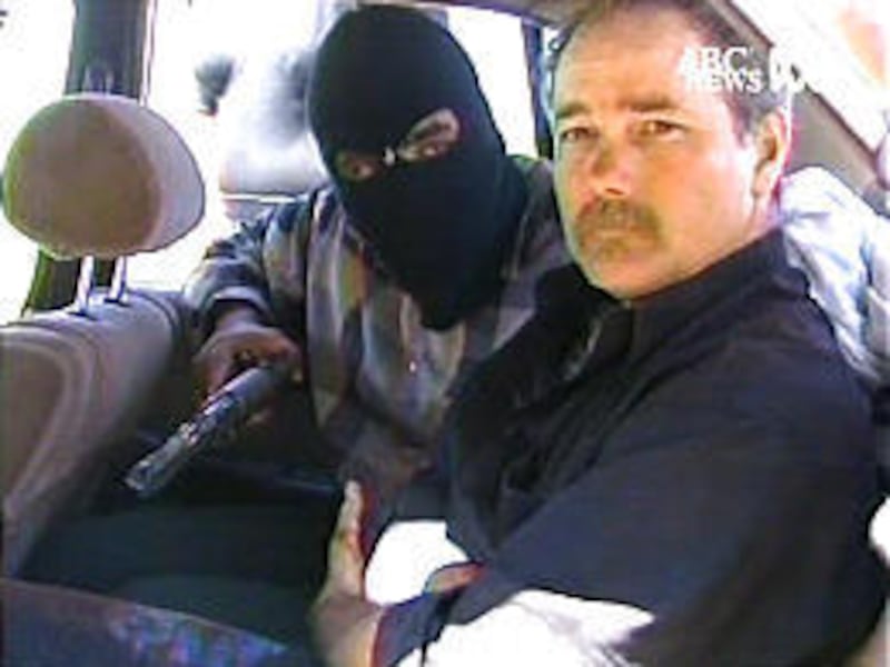 Thomas Hamill, an American, is held by Iraqi insurgents inside a car near Baghdad. The insurgents vow to kill him unless demands are met.