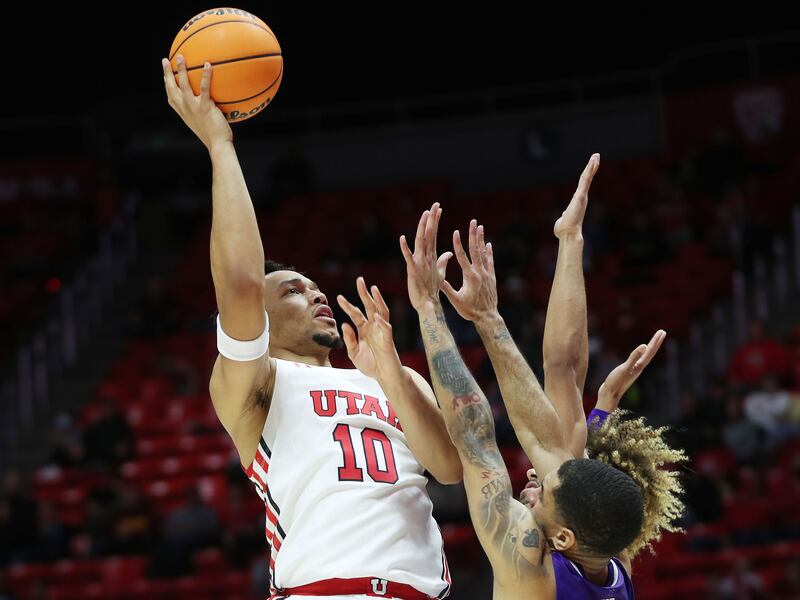 Utah Utes guard Marco Anthony, wearing white, goes for a shot