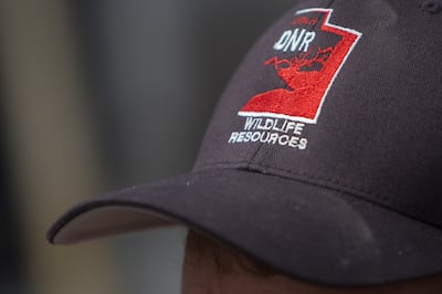 Dale Fonken, a native aquatics biologist with the Division of Wildlife Resources, wears a hat with the division's logo while releasing June suckers into Utah Lake at the American Fork Boat Harbor in American Fork on Monday, May 7, 2018.