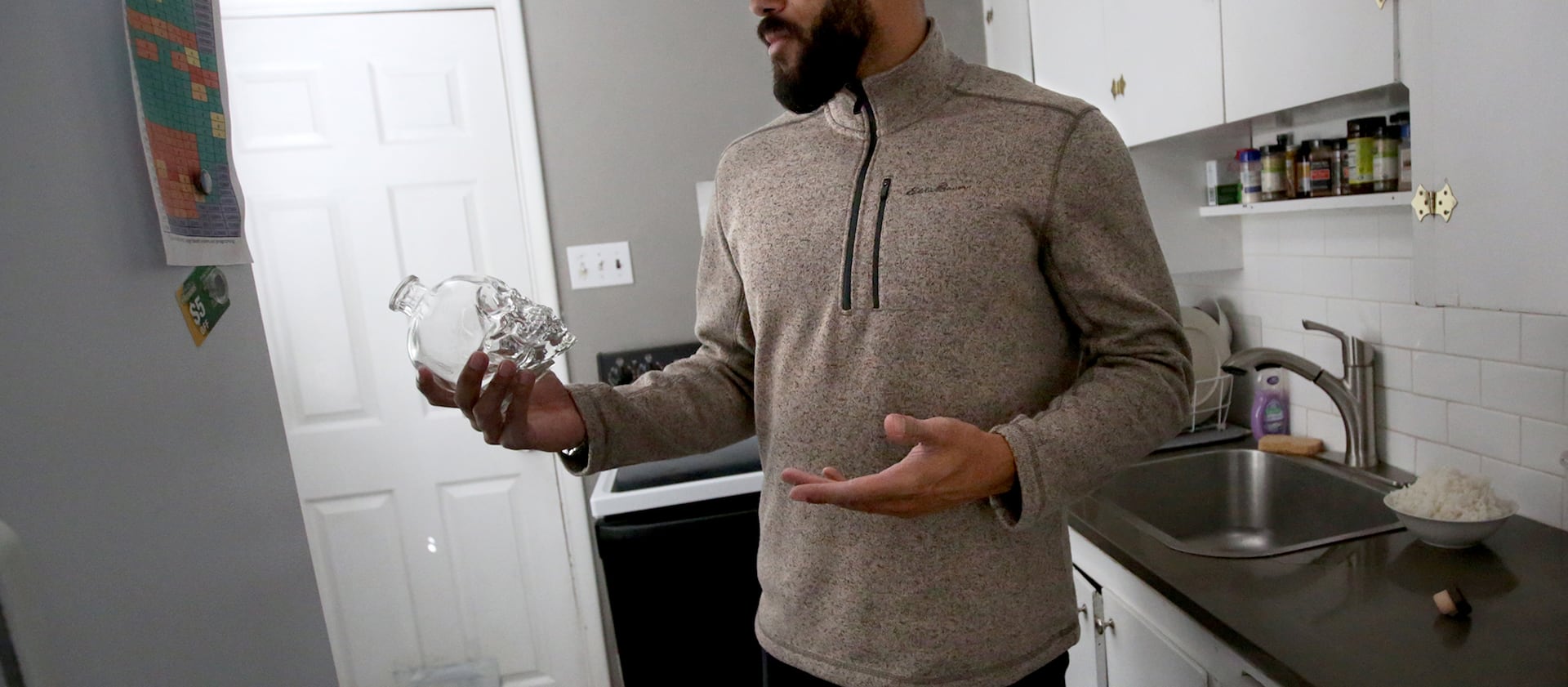 Christian Tyler holds a bottle that belonged to his best friend and cousin, who was shot to death, at his home in Salt Lake City on Monday, March 26, 2018.