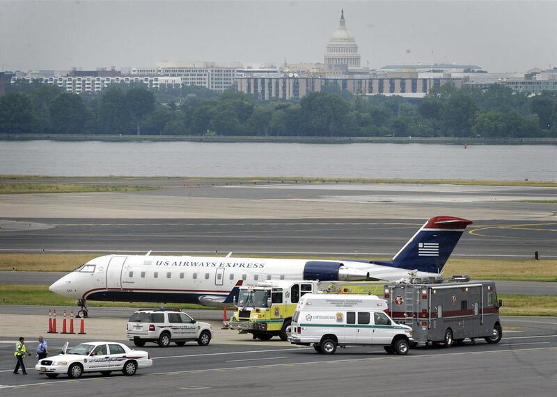 A US Airway plane sits on the tarmac at Reagan National Airport in Washington Sunday, June 19, 2011, surrounded by police and emergency vehicles after a bomb threat was made at an airport ticket counter in Ohio. When the plane landed, authorities swept th