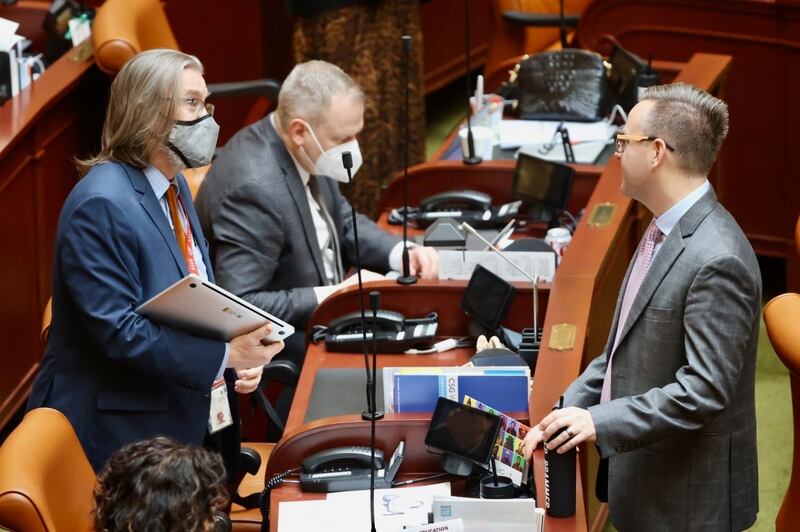 Rep. Joel Briscoe, D-Salt Lake City, talks with Rep. Brady Brammer, R-Highland, as Rep. Doug Owens, R-Millcreek, works behind them prior to the beginning of the forth day of Utah’s legislative session.