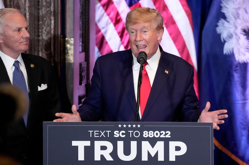 Former President Donald Trump speaks in front of a pulpit with an American Flag behind him.