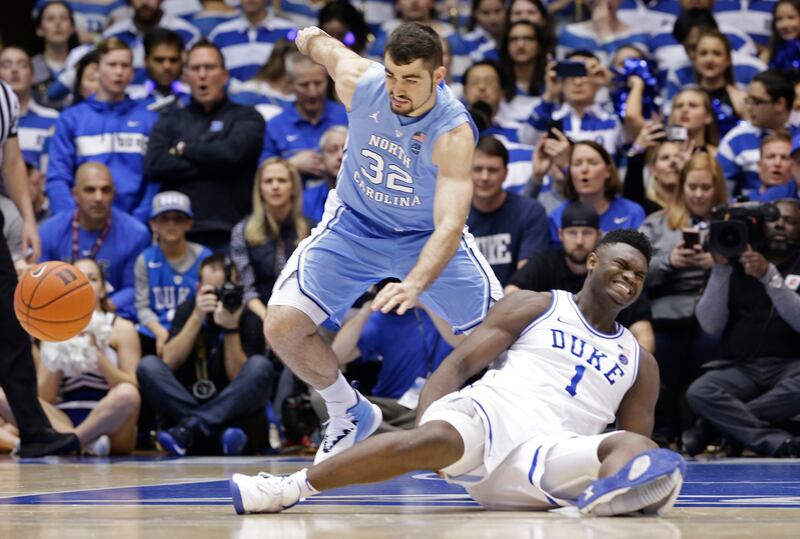 Duke's Zion Williamson (1) falls to the floor with an injury while chasing the ball with North Carolina's Luke Maye (32) during an NCAA college basketball game in Durham, N.C., Wednesday, Feb. 20, 2019. Williamson's shoe blew apart during the play.