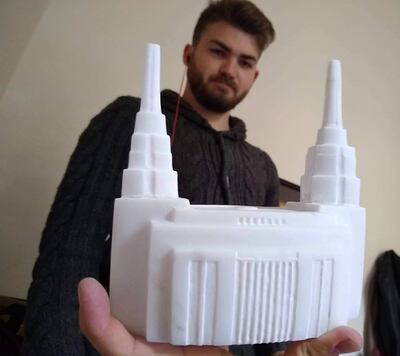 Bronson Evertsen holds one of his miniature replica Rome Temple sculptures that will help fund his mission.