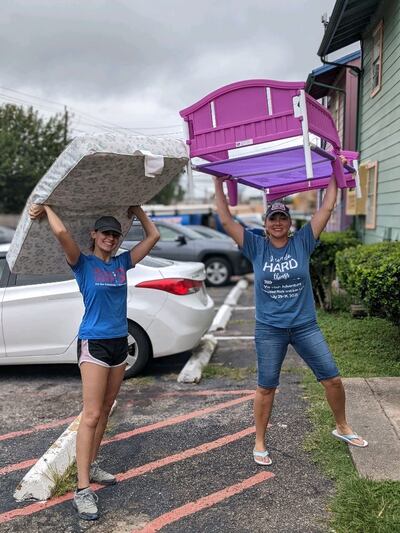 Volunteers carry a bed frame and mattress as part of a service project to furnish apartments for incoming refugee families in Houston.