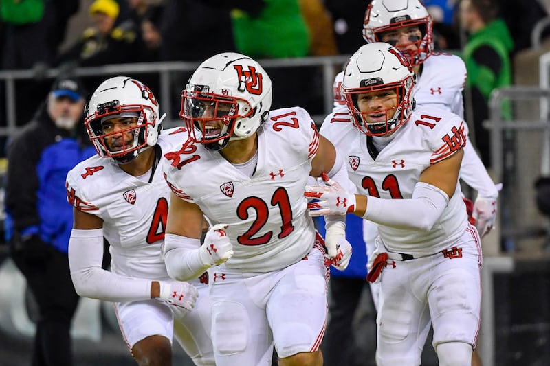 Utah linebacker Karene Reid (21) celebrates his touchdown on a recovered Oregon fumble with cornerback JaTravis Broughton (4) and safety R.J. Hubert (11) during the second half of an NCAA college football game Saturday, Nov. 19, 2022, in Eugene, Ore. (AP Photo/Andy Nelson)