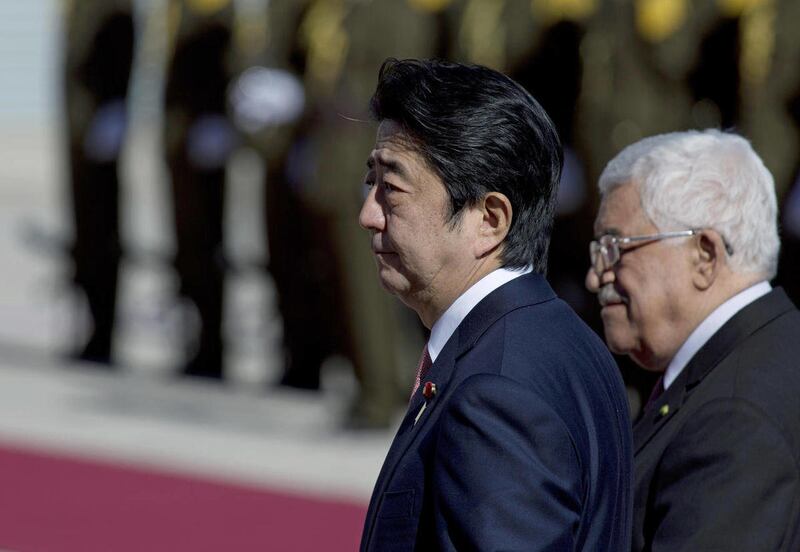 Palestinian President Mahmoud Abbas, right, escorts Japanese Prime Minister Shinzo Abe upon his arrival at the Palestinian Authority headquarters, in the West Bank city of Ramallah, Tuesday, Jan. 20, 2015. An online video released Tuesday purported to sho
