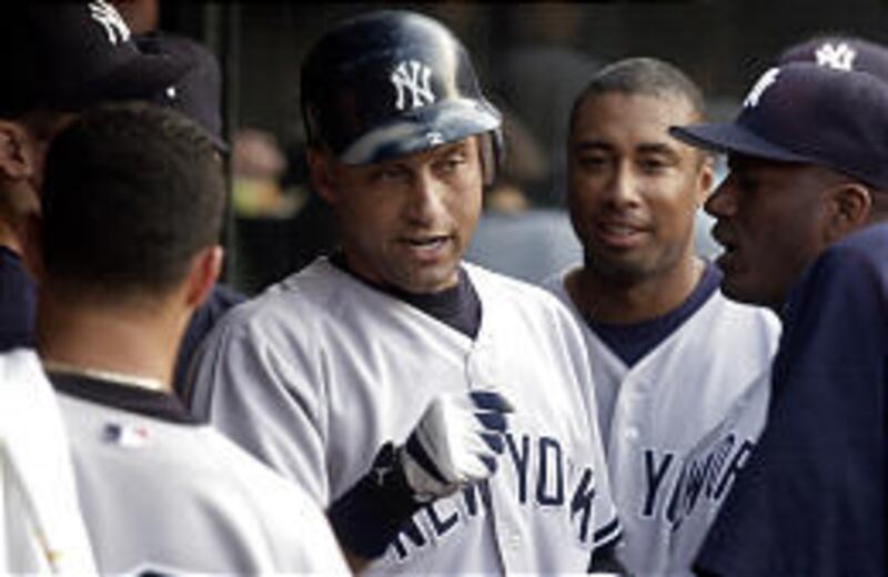 Derek Jeter is congratulated in the dugout after smacking a home run off Cleveland's Scott Elarton.
