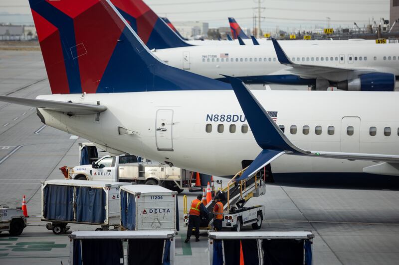 A ground crew loads bags onto a Delta Air Lines jet at Salt Lake City International Airport on Nov. 18, 2021.