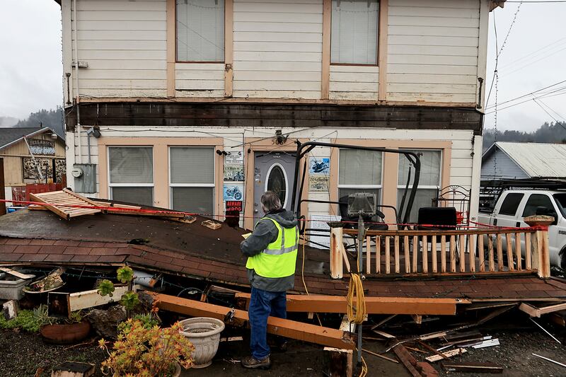 Building inspector Kevin Caldwell red tags a home in Rio Dell, Calif., that lost an awning and deck, after an earthquake hit Humboldt County, Tuesday, Dec. 20, 2022.