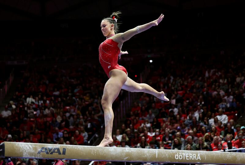 Utah’s Maile O’Keefe, wearing red, competes on the beam.