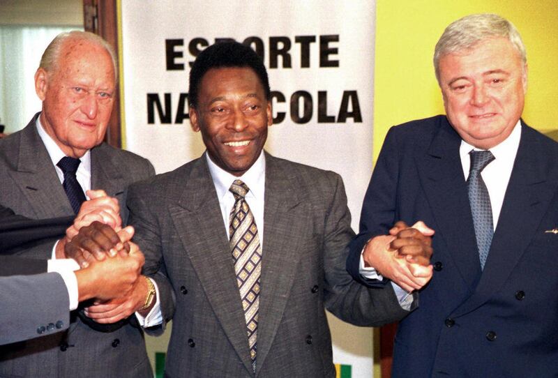 FILE - In this March 13, 2001 file photo, Brazil's former soccer player Pele , center, joins hands with former FIFA President Joao Havelange, left, and Ricardo Teixeira, president of the Brazilian Soccer Confederation, during a meeting to clean up Brazili