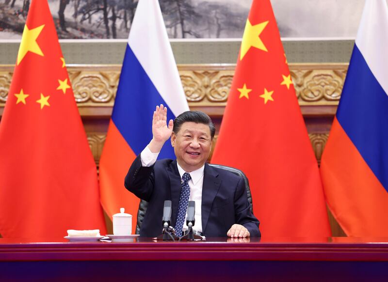 Chinese President Xi Jinping waves as he witnesses the ground-breaking ceremony of a bilateral nuclear energy cooperation project, Tianwan nuclear power plant and Xudapu nuclear power plant, via video link with his Russian counterpart Vladimir Putin from Beijing.