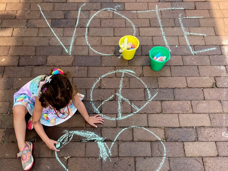 The oldest daughter of Lindsey Lurie fills in where her mother drew a heart on the sidewalk Tuesday, July 5, 2022.