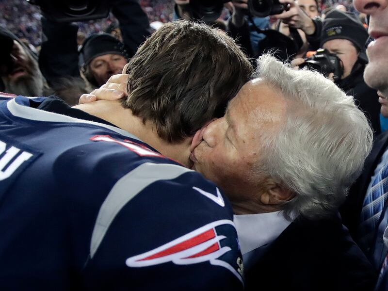New England Patriots owner Robert Kraft kisses quarterback Tom Brady at midfield after a game, Sunday, Jan. 21, 2018.