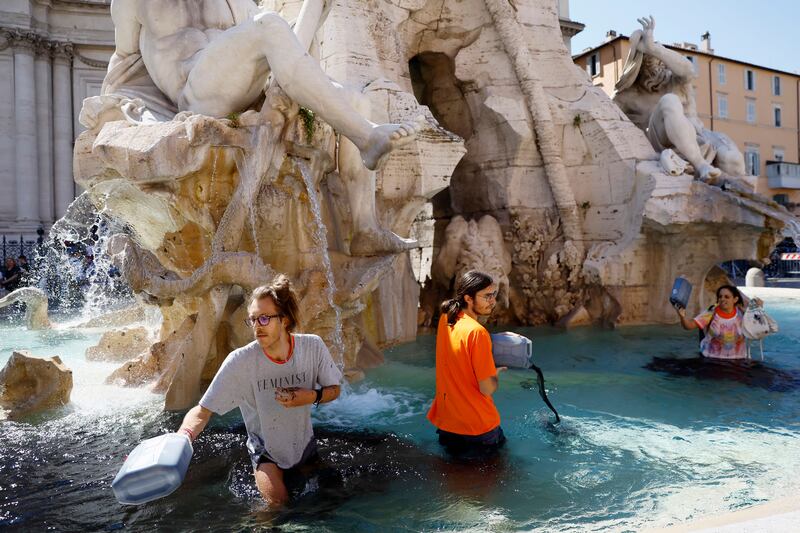 Activists of climate group Last Generation stage a demonstration inside the Quattro Fiumi fountain, in Rome, May 6, 2023.